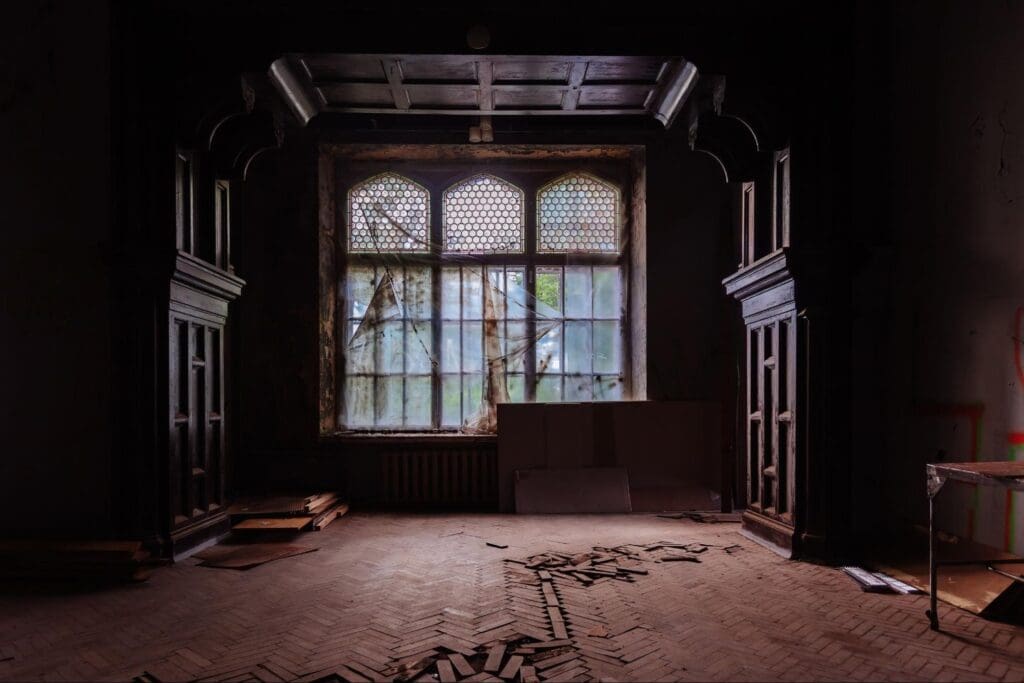 Abandoned hall with decayed walls and broken wooden floor
